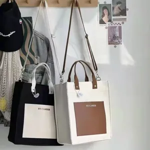 Detailed view of casual canvas tote bag with contrast pocket, shoulder strap, and sturdy design.