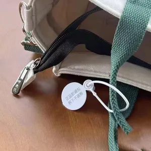 Close up detail view of canvas handbag showing quality zipper pull and sturdy strap design.