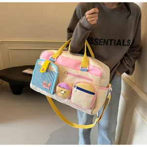 Detailansicht einer bunten Dopamin Reisetasche mit mehreren Taschen und Schultergurt.
