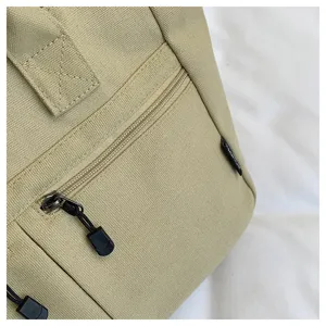 Close-up detail of khaki canvas tote bag featuring durable fabric, zipper pocket and clean stitching.