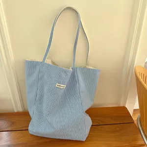 Detail shot of blue and white striped canvas tote bag showing textured fabric and casual design.
