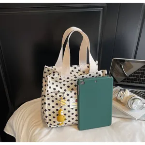 Chic black and white polka dot canvas handbag with adorable pendant for daily casual use.