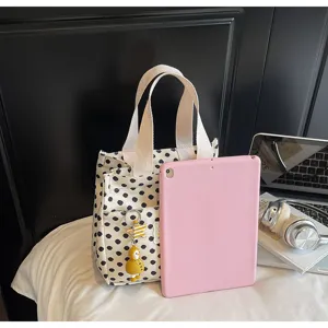 Minimalist black and white polka dot canvas tote bag with top handles and cute charm.