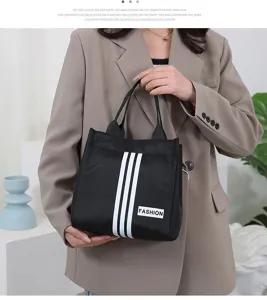 Casual black canvas tote bag with white vertical stripes and fashion label for daily use.