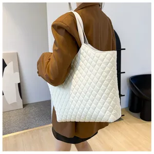 White quilted tote bag detail shot, casual shoulder bag with classic diamond pattern.