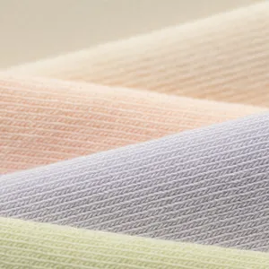 Detailed macro view of soft pastel knitted cotton fabric showcasing fine vertical ribs.