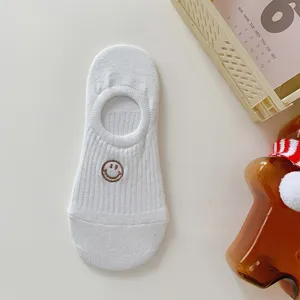 White low-cut cotton invisible boat socks with cute embroidered smiley face design.
