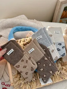 Cozy wool blend mid-calf socks featuring trendy leopard print color-block design and chic fabric label.