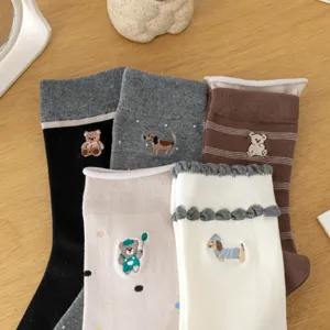 Detailed shot of cute Japanese style cartoon embroidered socks with cute bear and dog patterns.