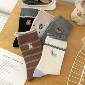 Close-up detail of cute cartoon embroidered mid-calf socks with sweet animal patterns.