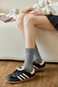 Detailed close-up shot of cute dog embroidered gray mid-calf socks with dots, cozy wear.