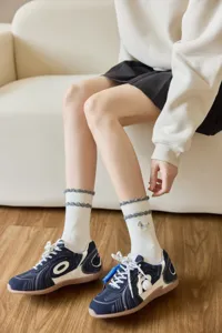 Close-up of Japanese cute dog embroidered ruffle mid-tube socks, perfect for autumn style.