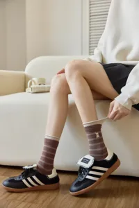 Detailed shot of brown striped bear embroidered mid-tube socks, cute roll-cuff student style.