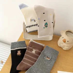 Detailed view of cute embroidered cartoon mid-calf socks with playful rolled cuffs.