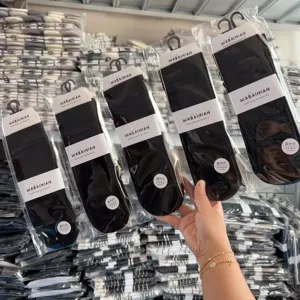 Women modal solid black slouch socks, long tube casual hosiery packaged in bulk display.