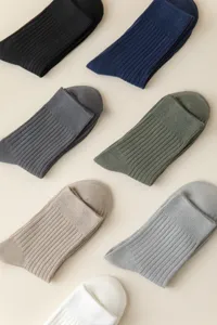 Close up of ribbed cotton men's socks in multiple solid colors, neat flat lay detail view.