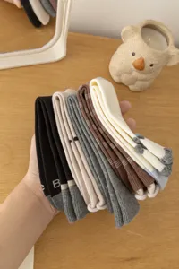 Detailed shot of cute Japanese style college mid tube socks with rolled cuffs and various colors.