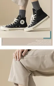 Classic men's high-top canvas sneakers paired with stylish socks and casual trousers for daily wear.