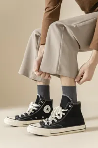Detailed close-up view of men's grey ribbed cotton socks paired with classic black canvas shoes.
