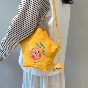 Yellow star shaped canvas crossbody bag detail view with cute cartoon print and pendant.
