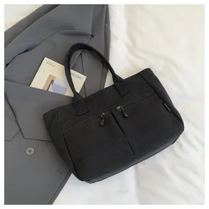 Casual black canvas tote bag with front zipper pockets, versatile daily commuter handbag.