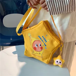 Yellow star shaped canvas crossbody bag with cute cartoon print and plush pendant for daily use.