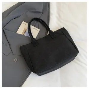 Simple black canvas tote bag detail, casual minimalist style for daily commuting and school use.