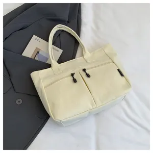 Minimalist canvas tote bag with zipper pockets, casual commuter handbag for daily student use.