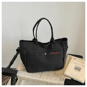 Black canvas tote bag large capacity casual shoulder handbag with red embroidered lettering for women.