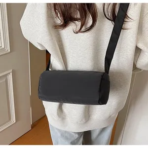 Black nylon cylindrical crossbody pillow bag, simple casual underarm shoulder bag for women.
