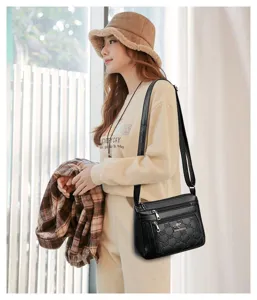 Detailed view of the black soft leather shoulder bag featuring multi-pocket design and strap.