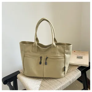 Casual minimalist canvas tote bag with front zipper pockets and sturdy handles for daily use.