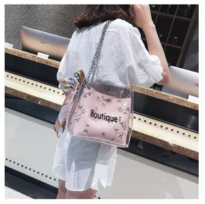 Transparent PVC jelly shoulder bag featuring floral embroidery, pink inner pouch and chain strap.