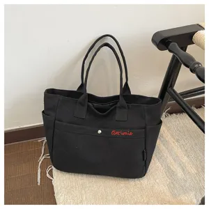 Black canvas tote bag large capacity casual shoulder handbag with red embroidery detail.