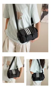 Black nylon crossbody bag with three white stripes, casual sporty shoulder bag for women commute.