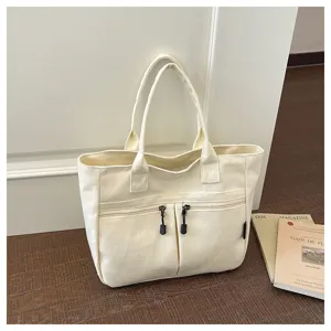 Detailed view of casual canvas tote bag with front zip pockets and handles for daily use.