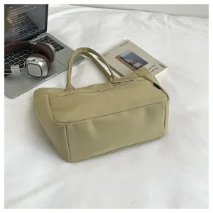 Detailed shot of casual khaki canvas tote bag with blue embroidery and spacious daily storage.