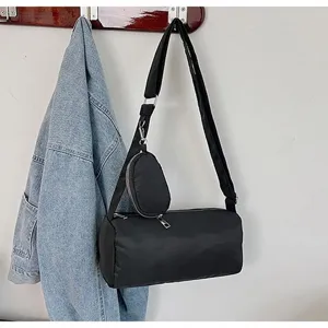 Detailed view of the black cylindrical shoulder bag hanging on the wall hook display.