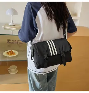 Detailed view of the black nylon messenger bag with three stripes design for daily commute.