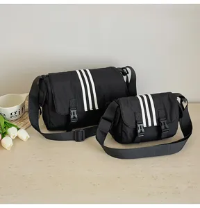 Detailed shot of black nylon crossbody bags featuring athletic three stripes, casual style.