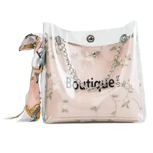 Clear PVC jelly crossbody bag with pink floral embroidered inner pouch and chain strap.
