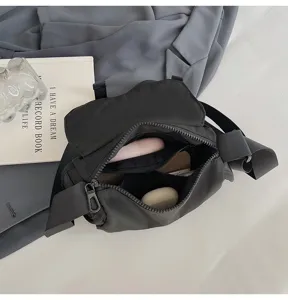 Detailed view of the black nylon crossbody bag interior, featuring multiple compartments.