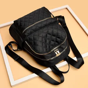 Black quilted nylon backpack for women casual stylish travel bookbag with gold zippers.
