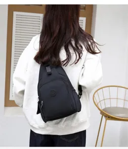 Detailed view of the black nylon sling backpack showing multi compartments and durable zippers.