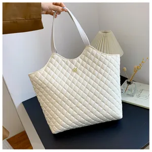 Close-up detail of the stylish quilted tote bag with diamond pattern and gold accent.