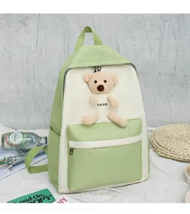 Cute canvas school backpack for teenage girls with bear pendant and large capacity.