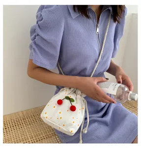 Sac seau brodé de fleurs blanches avec charmant pendentif cerise pour femme sac bandoulière.