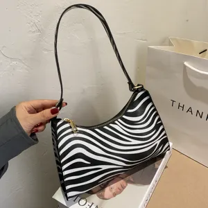 Detail view of stylish black and white zebra pattern underarm shoulder bag with metal zipper.