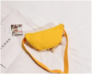 Detailed view of yellow canvas crossbody chest bag featuring cute bear plush accents and strap.