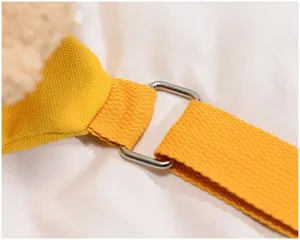 Canvas bag strap detail close-up showing yellow webbing and metal adjustment buckle.